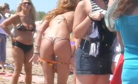 The perverted camera man is voyeuring a beautiful bikini butt of the cute amateur gal